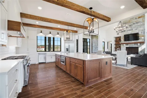 a large kitchen with stainless steel appliances granite countertop a lot of cabinets and wooden floor