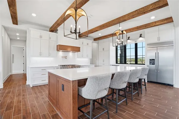 a kitchen with stainless steel appliances a table and chairs in it