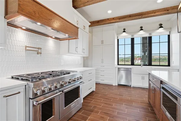 a kitchen with stainless steel appliances a stove a sink and a refrigerator