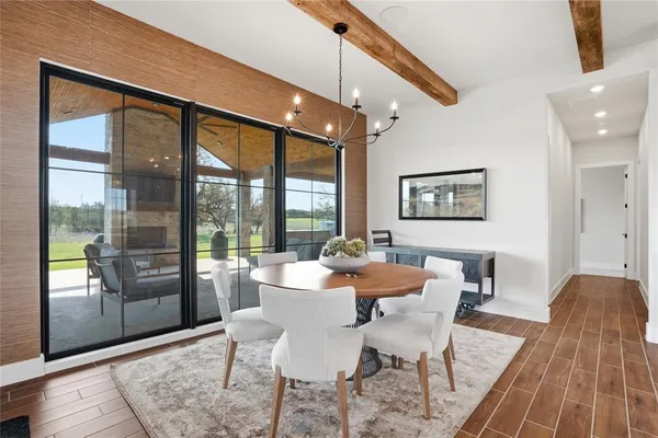 a dining room with furniture a chandelier and wooden floor