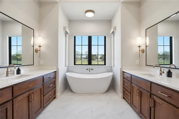 a spacious bathroom with a double vanity sink mirror bathtub and window