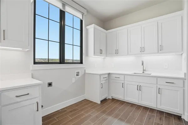 a kitchen with granite countertop white cabinets and sink