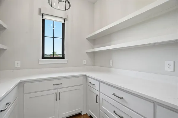 a kitchen with white cabinets and a window