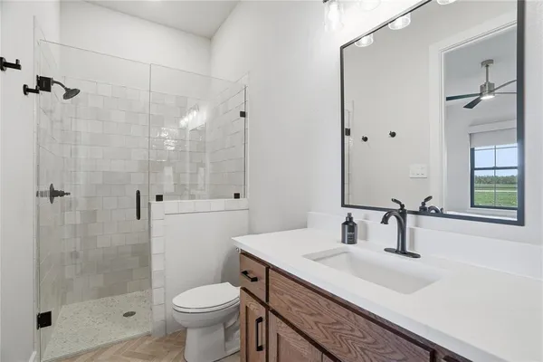 a bathroom with a sink toilet a mirror and shower