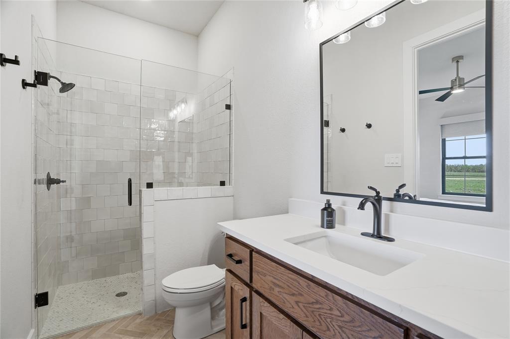 1010 Ranger Ridge Way Strawn, TX 76475 - Photo 30 of 40 a bathroom with a sink toilet a mirror and shower