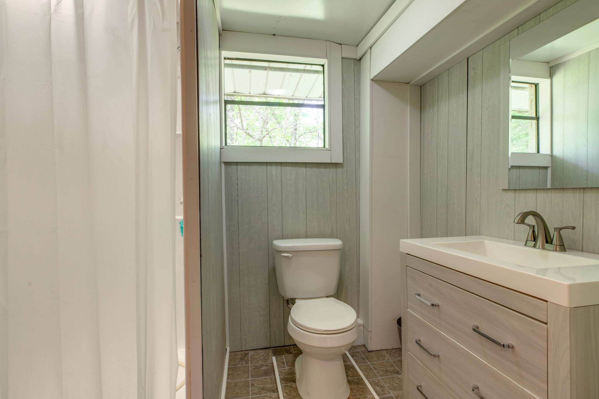 7196 Pinewood Road Nunnelly, TN 37137 - Photo 19 of 49 a bathroom with a toilet a sink a vanity and a window