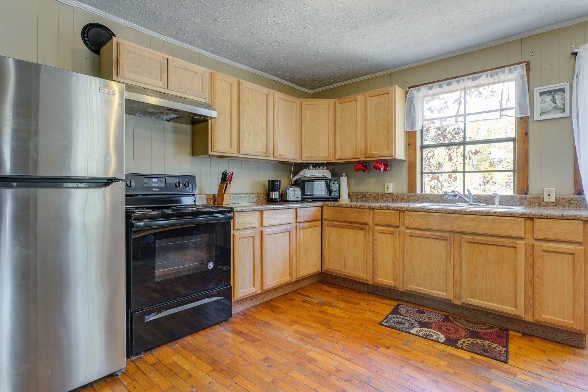 7196 Pinewood Road Nunnelly, TN 37137 - Photo 9 of 49 a kitchen with a refrigerator stove and white cabinets