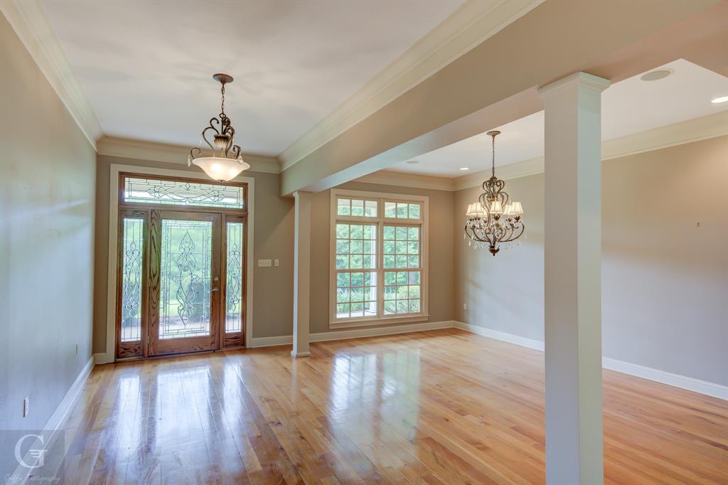 1212 WPA Road Homer, LA 71040 - Photo 10 of 35 Foyer entrance with ornamental molding, a chandelier, light wood-type flooring, baseboards, and ornate columns