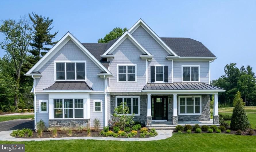 a front view of a house with a yard and potted plants