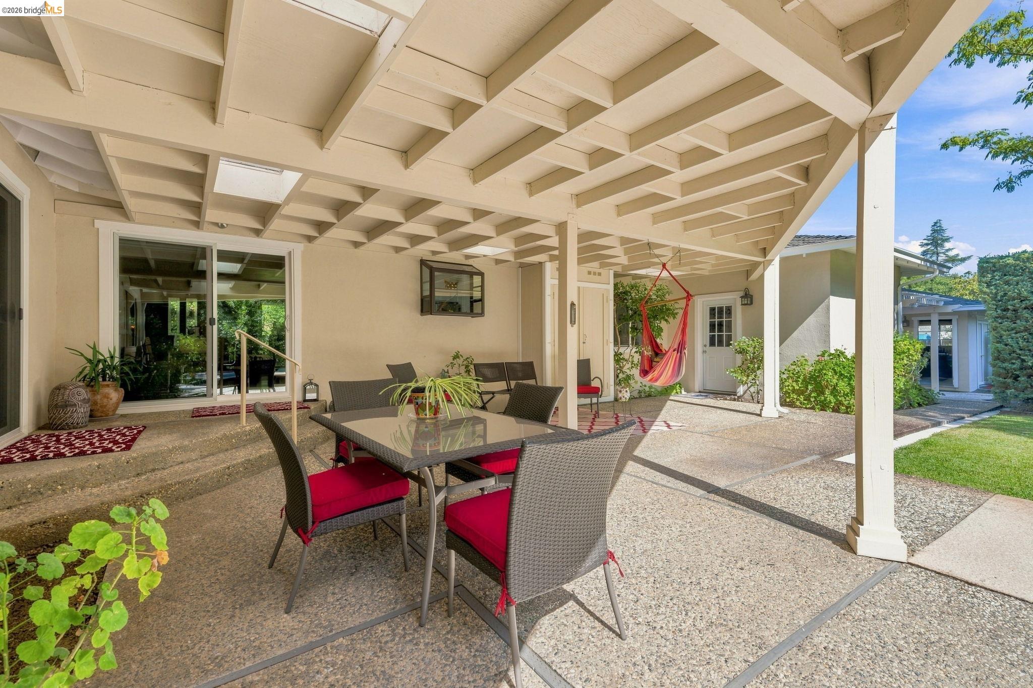 5075 Alhambra Valley Road Martinez, CA 94553 - Photo 34 of 68 Expansive covered patio featuring an exposed aggregate surface, a lattice-style ceiling with skylights, and direct access through sliding glass doors