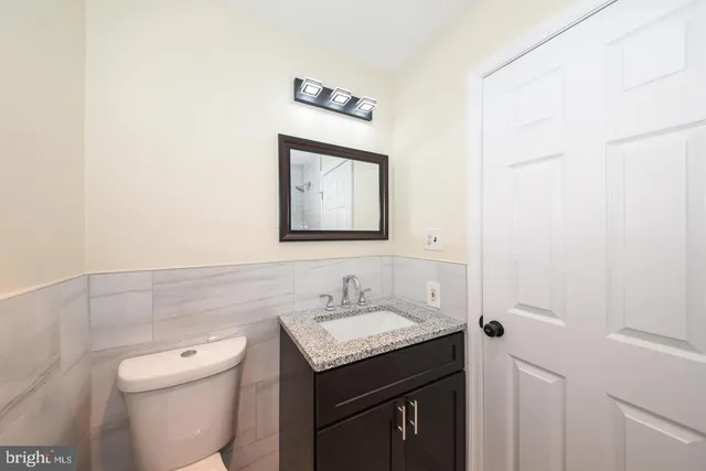 a bathroom with a toilet a sink and mirror