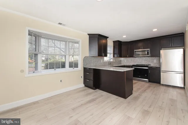 a kitchen with stainless steel appliances granite countertop a stove a sink and a refrigerator