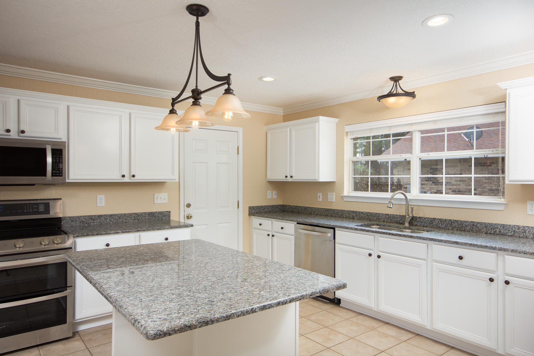 166 East Shipwreck Road Santa Rosa Beach, FL 32459 - Photo 11 of 33 a kitchen with granite countertop a sink a counter top space appliances and cabinets