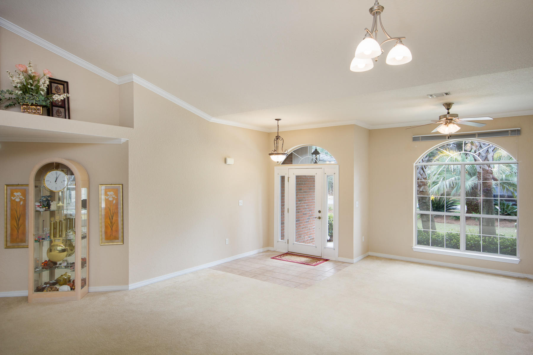 166 East Shipwreck Road Santa Rosa Beach, FL 32459 - Photo 3 of 33 an empty room with windows chandelier fan and wooden floor