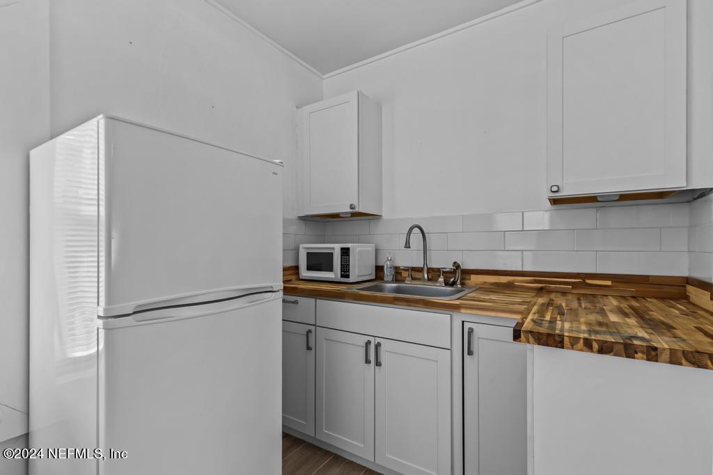 313 A St George Street St. Augustine, FL 32084 - Photo 11 of 21 a kitchen with stainless steel appliances granite countertop white refrigerator a stove a sink and a white cabinets