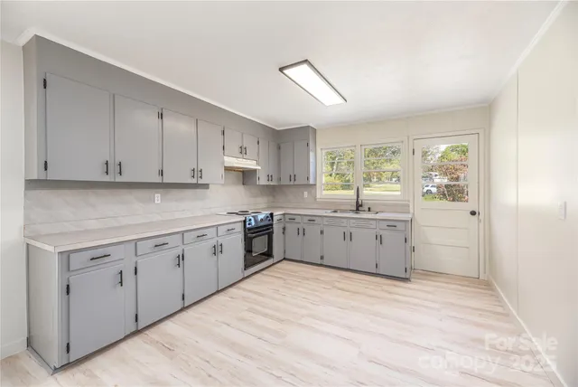 a kitchen with sink a window and cabinets