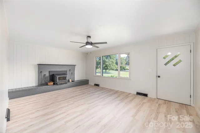 a view of an empty room with a fireplace and a window