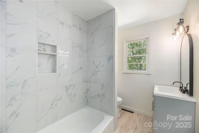 a bathroom with a tub a sink a window and a shower