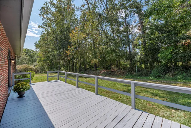 a view of deck with seating and trees
