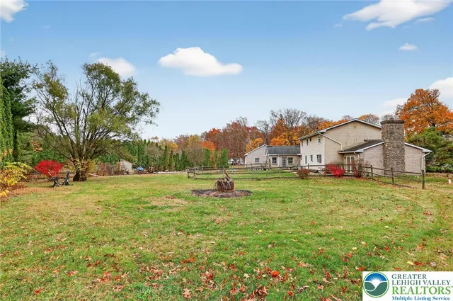 a view of an house with backyard and trees