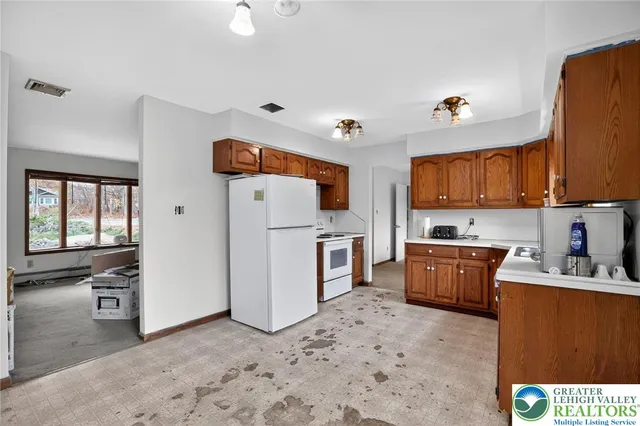 a kitchen with refrigerator cabinets and window