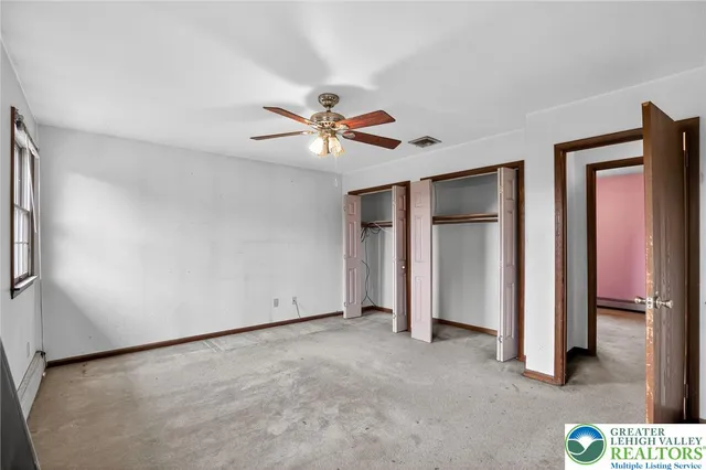 a view of an empty room with a ceiling fan