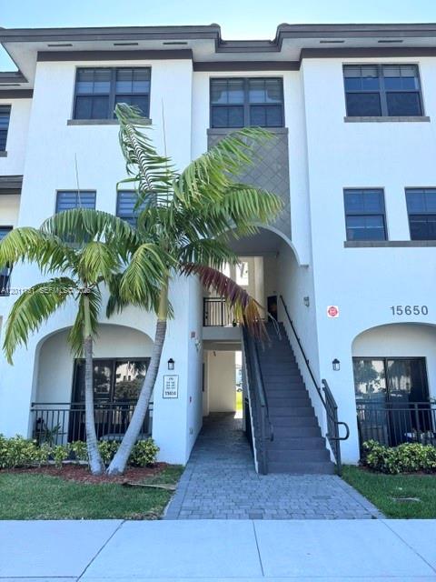 15650 Southwest 136th Street, Unit 101 Miami, FL 33196 - Photo 1 of 16 a front view of house with yard