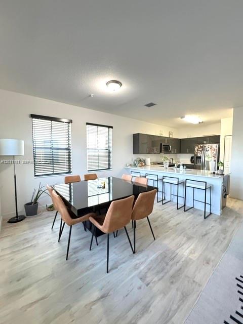 15650 Southwest 136th Street, Unit 101 Miami, FL 33196 - Photo 5 of 16 a dining room with furniture and wooden floor