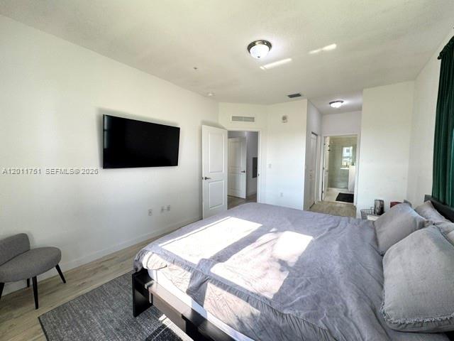 15650 Southwest 136th Street, Unit 101 Miami, FL 33196 - Photo 7 of 16 a bedroom with a bed and a flat screen tv