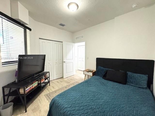 15650 Southwest 136th Street, Unit 101 Miami, FL 33196 - Photo 10 of 16 a bedroom with a bed and a flat screen tv