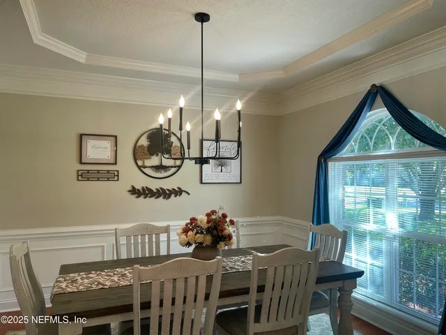 a view of a dining room with furniture wooden floor and chandelier