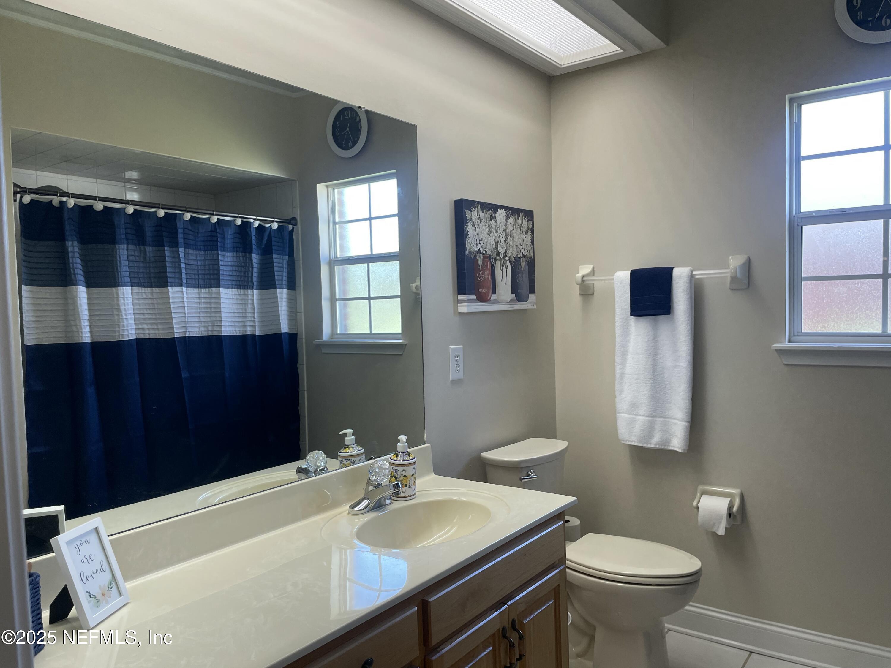 1168 Copper Gate Place Macclenny, FL 32063 - Photo 35 of 44 a bathroom with a sink toilet a mirror and shower