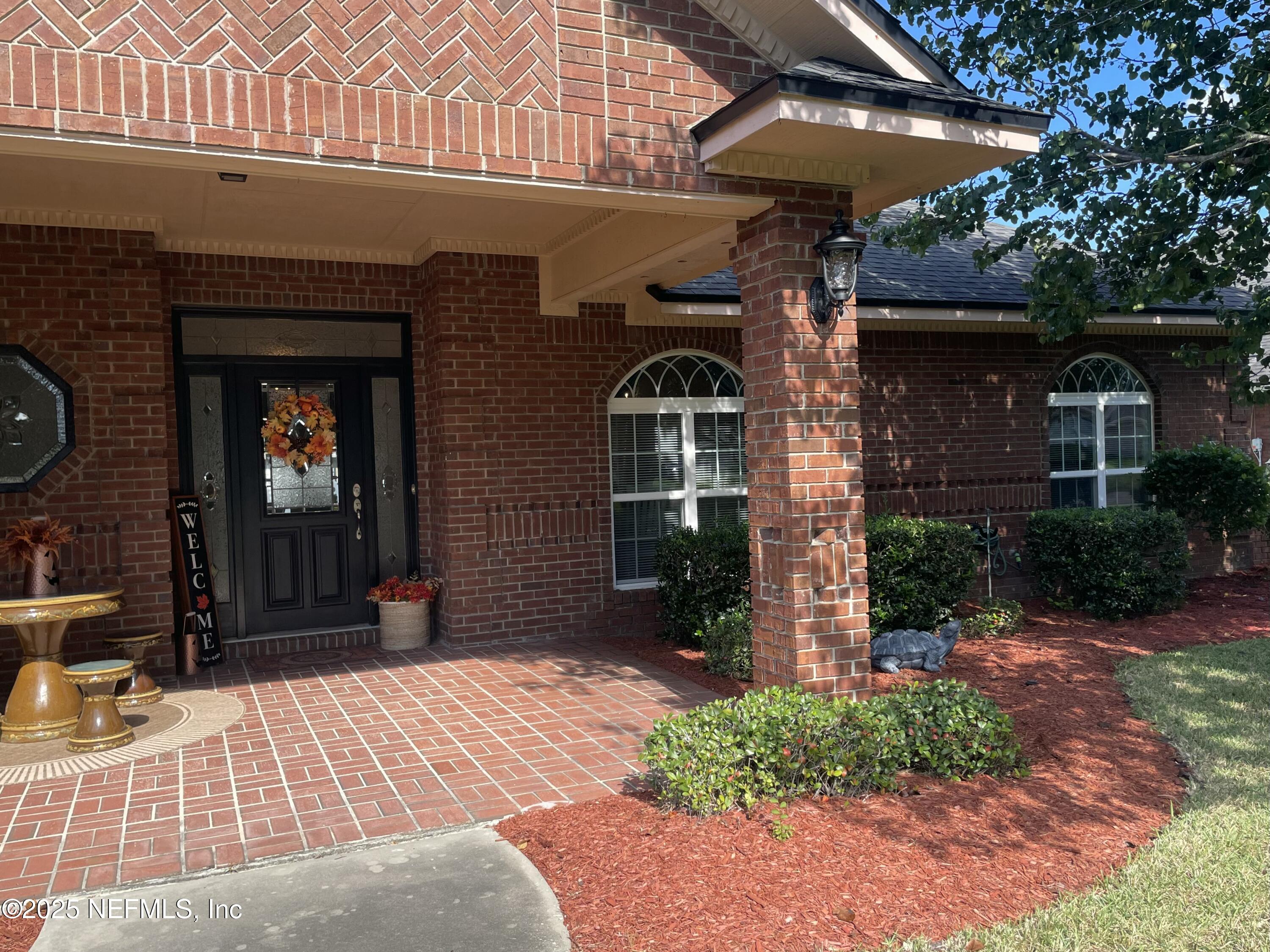 1168 Copper Gate Place Macclenny, FL 32063 - Photo 6 of 44 a front view of a building with a garden