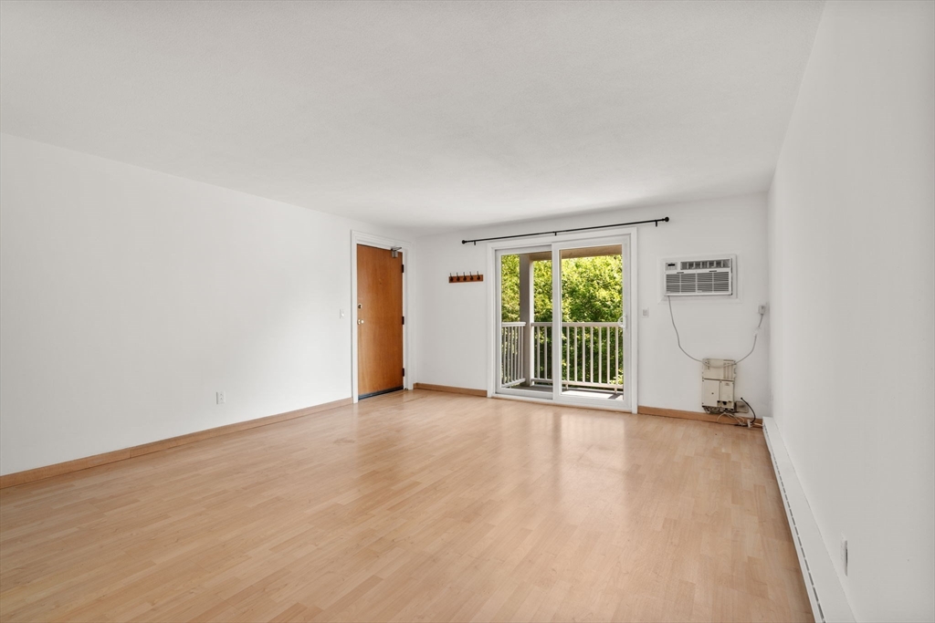 47 Will Drive, Unit 114 Canton, MA 02021 - Photo 16 of 25 an empty room with wooden floor and windows