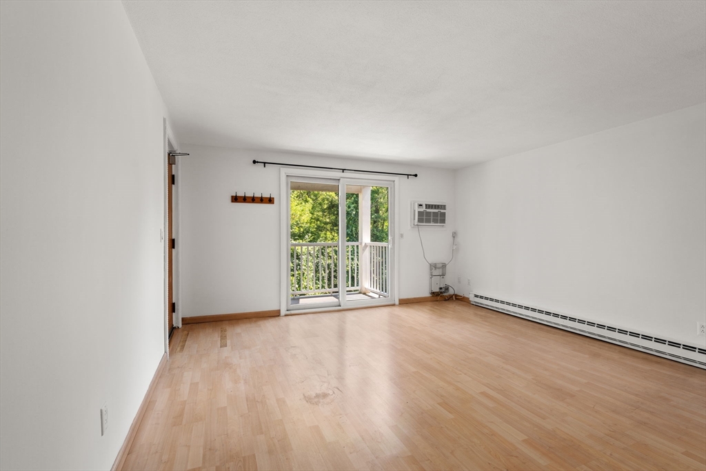 47 Will Drive, Unit 114 Canton, MA 02021 - Photo 18 of 25 an empty room with wooden floor and windows