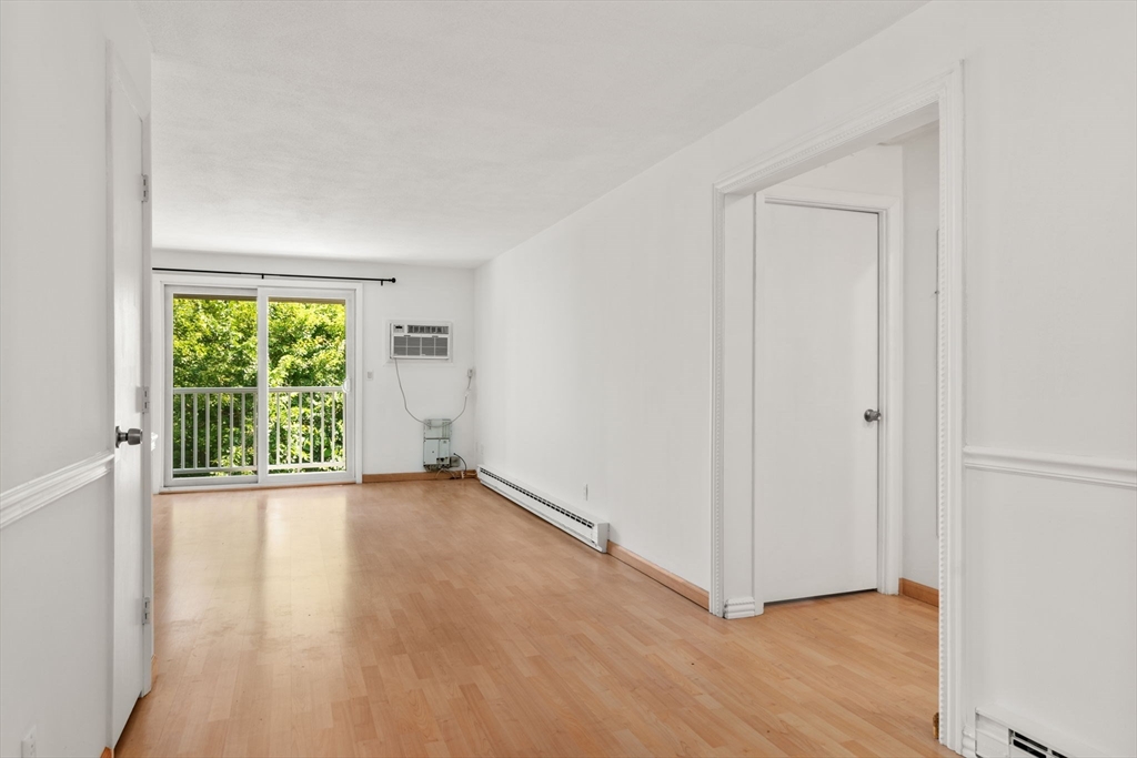 47 Will Drive, Unit 114 Canton, MA 02021 - Photo 21 of 25 an empty room with wooden floor and windows
