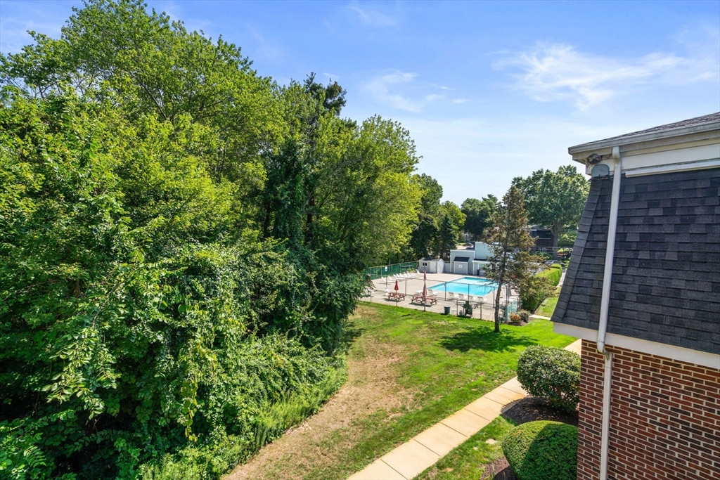 47 Will Drive, Unit 114 Canton, MA 02021 - Photo 22 of 25 a view of a backyard with couches plants and large trees