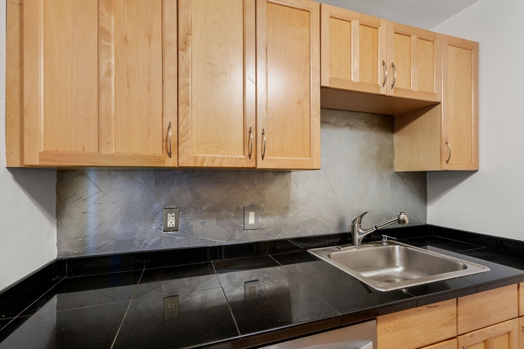 47 Will Drive, Unit 114 Canton, MA 02021 - Photo 6 of 25 a kitchen with granite countertop a sink and cabinets