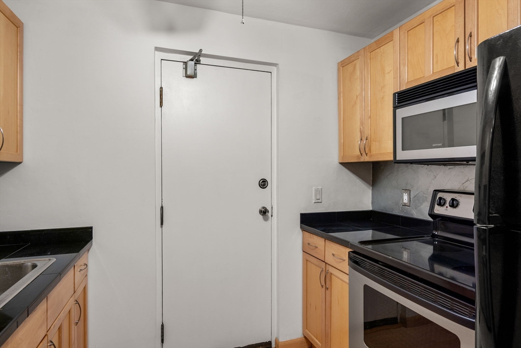 47 Will Drive, Unit 114 Canton, MA 02021 - Photo 7 of 25 a kitchen with stainless steel appliances granite countertop white cabinets and a stove top oven