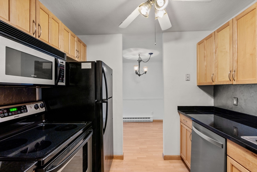 47 Will Drive, Unit 114 Canton, MA 02021 - Photo 8 of 25 a kitchen with a sink appliances and cabinets