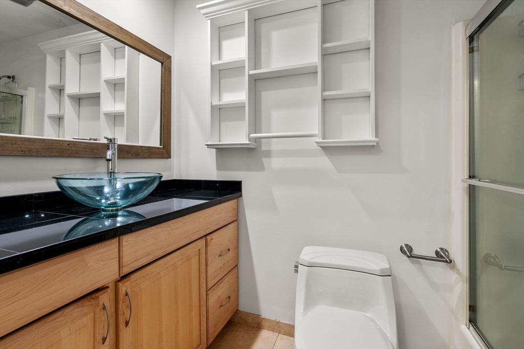 47 Will Drive, Unit 114 Canton, MA 02021 - Photo 9 of 25 a bathroom with a granite countertop sink a toilet and a mirror