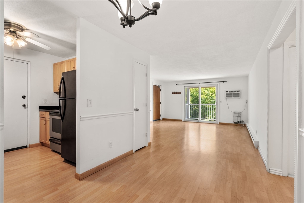 47 Will Drive, Unit 114 Canton, MA 02021 - Photo 10 of 25 a view of a room with wooden floor ceiling fan and windows