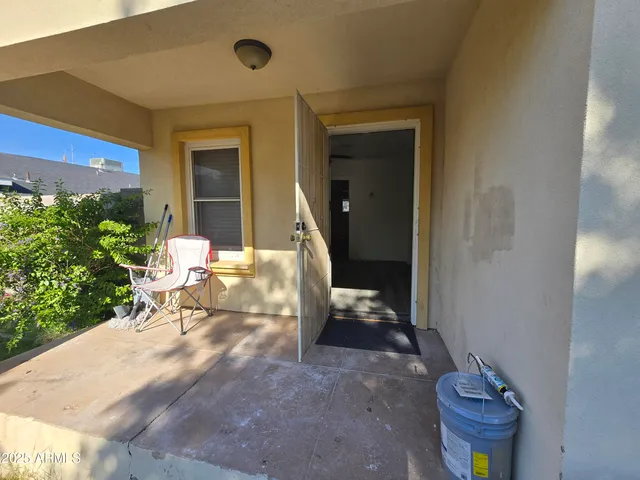 a view of a porch with chairs and potted plants