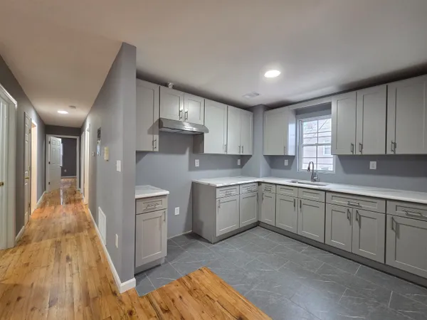 a kitchen with cabinets a sink and wooden floor