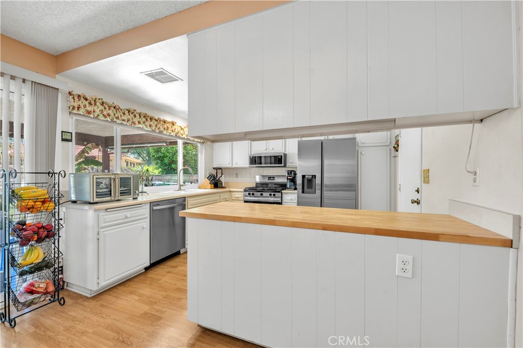 1114 Bottle Tree Way Hemet, CA 92545 - Photo 12 of 25 a kitchen with stainless steel appliances granite countertop a sink and cabinets