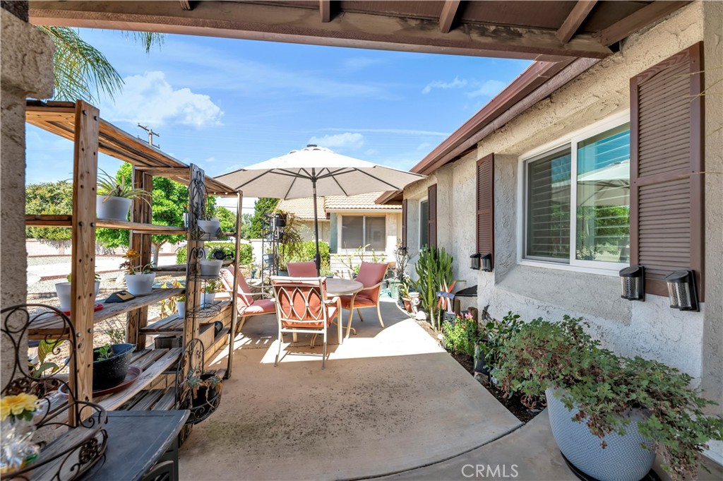 1114 Bottle Tree Way Hemet, CA 92545 - Photo 6 of 25 a view of a patio with table and chairs under an umbrella