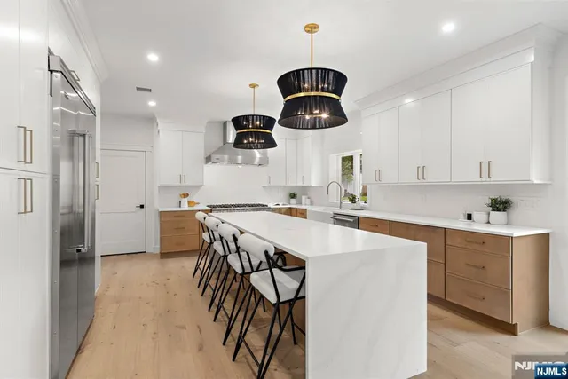 a kitchen with stainless steel appliances a center island and a refrigerator