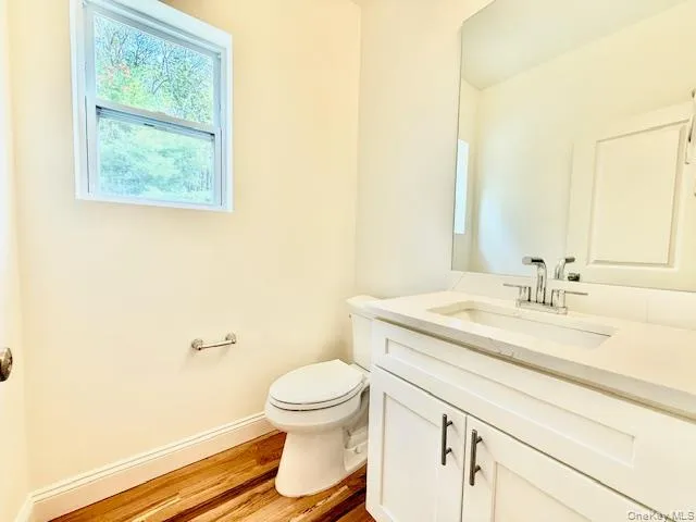 a bathroom with a granite countertop sink mirror vanity and toilet