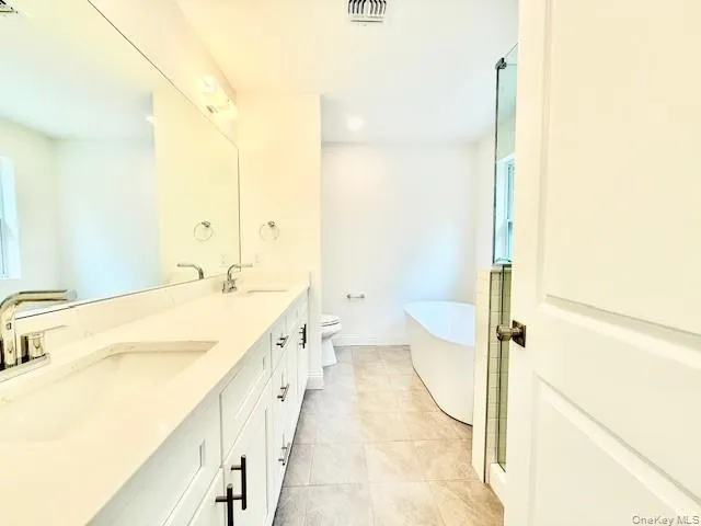 a spacious bathroom with a tub sink and toilet