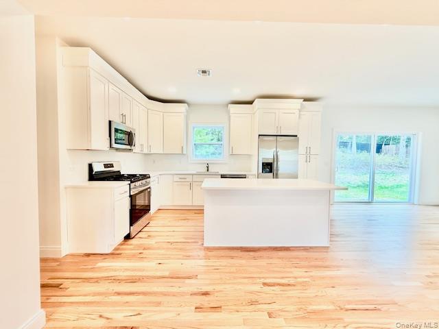 120 River Road Shirley, NY 11967 - Photo 9 of 27 a living room with stainless steel appliances kitchen island granite countertop a stove a sink and white cabinets